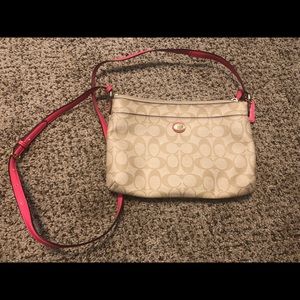 Coach crossbody purse with pink strap.